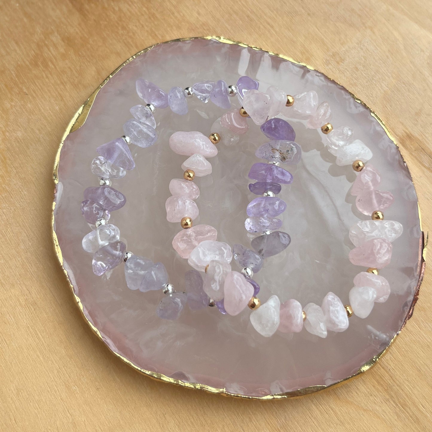 Amethyst and rose quartz chip beaded bracelets presented on stone tray