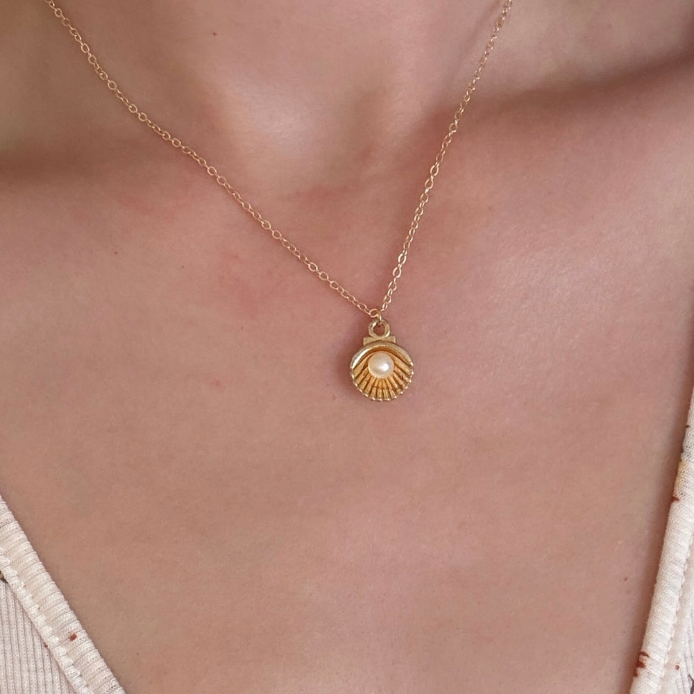 
                      
                        Gold plated oyster charm necklace with pearl detail
                      
                    