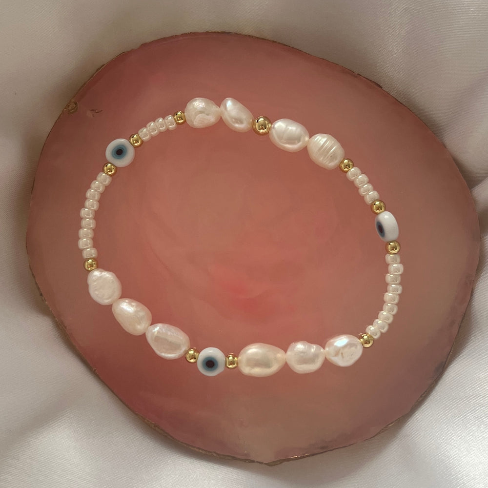 
                      
                        Light blue evil eye and pearl bracelet
                      
                    