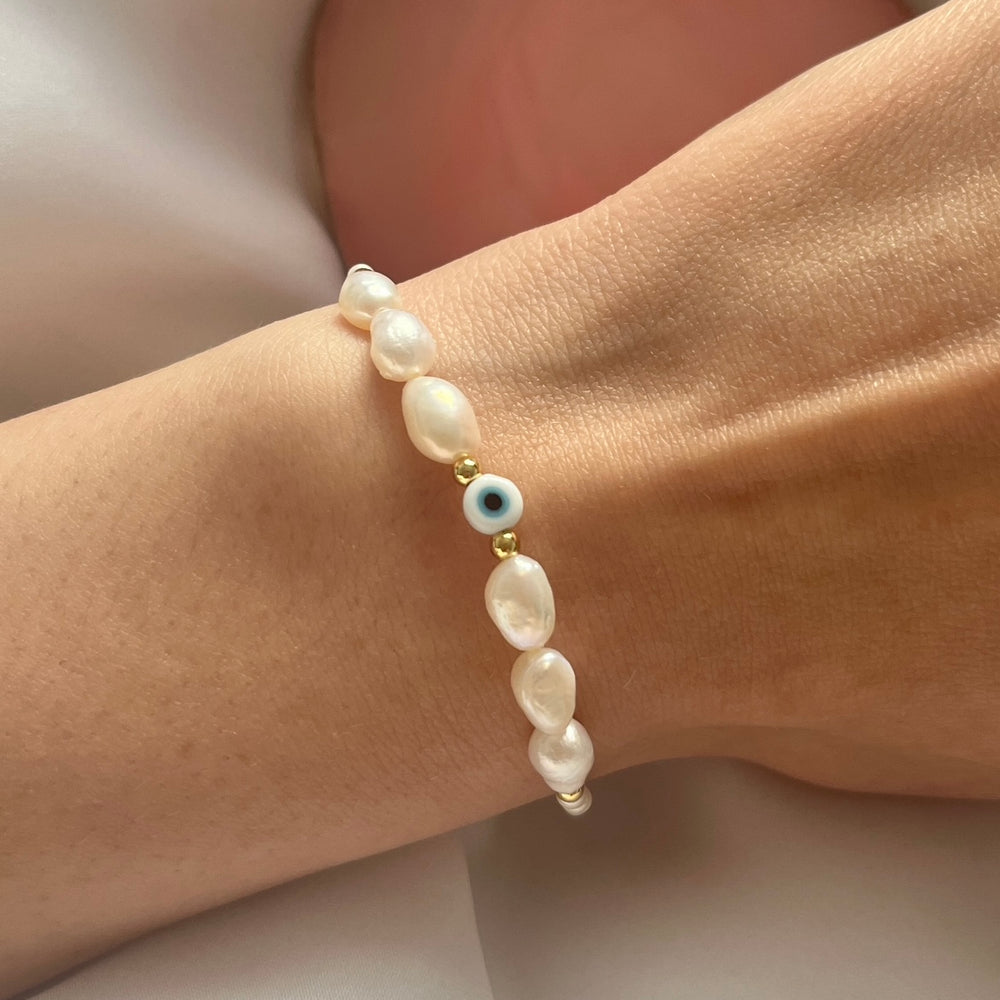 
                      
                        Light blue evil eye and pearl bracelet
                      
                    