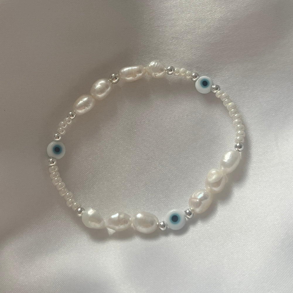 
                      
                        Light blue evil eye and pearl bracelet
                      
                    